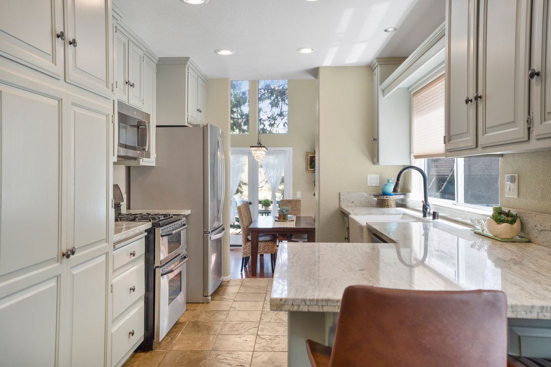 Kitchen with an island, bar seating and white cabinetry.